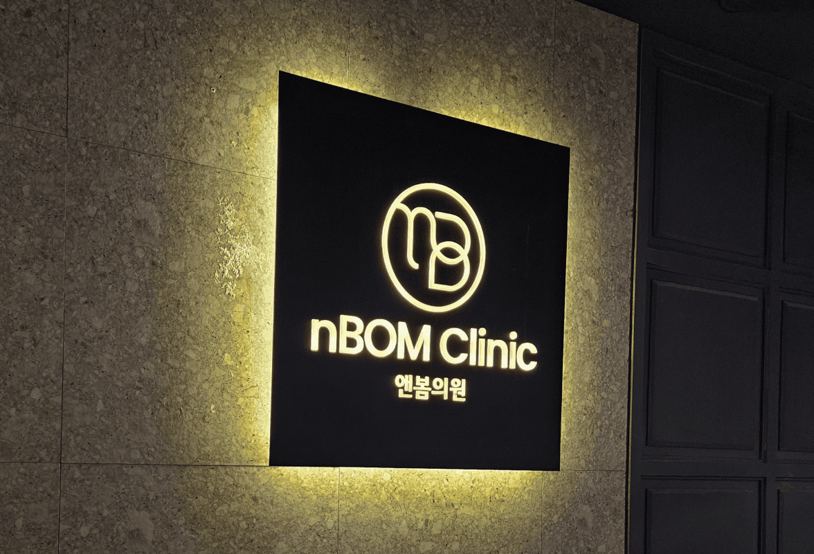 The illuminated nBOM Clinic sign at the clinic entrance